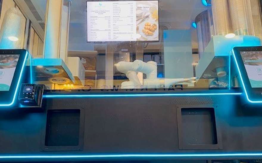 Illuminated Barista.Bot kiosk front with the menu screen and cup dispensers